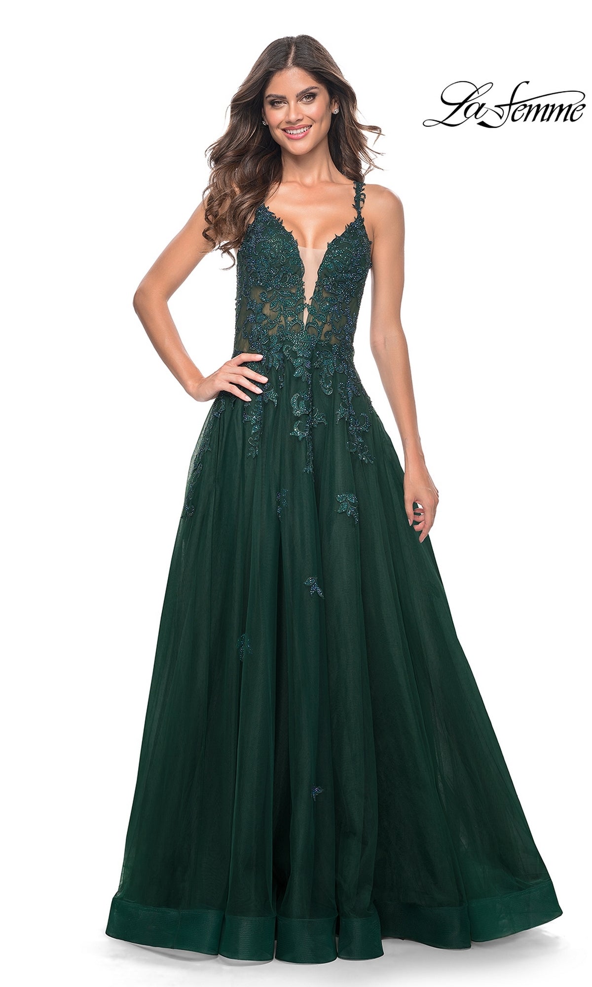 A woman smiles in the La Femme Embroidered-Lace Long Prom Gown 32022, featuring a dark green lace bodice and tulle a-line skirt, standing against a white background with the